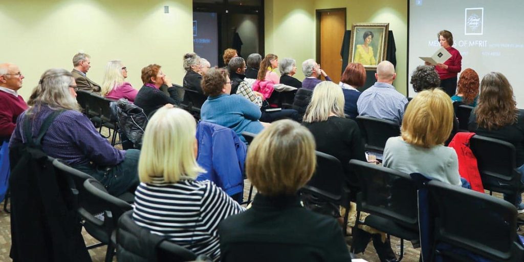 Photo of Lora speaking at a PSA meeting.