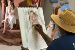 A man drawing from a live model