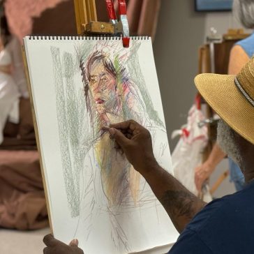 A man drawing from a live model