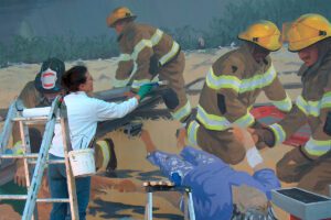 Cheryl Mann painting a mural.